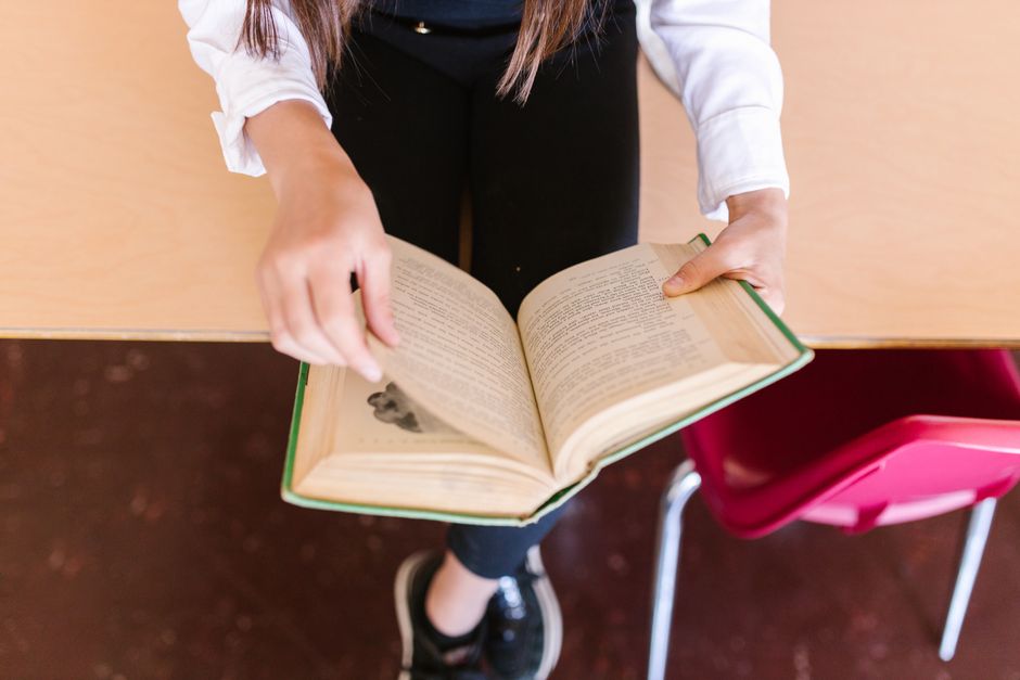 A student reading an open book at a desk